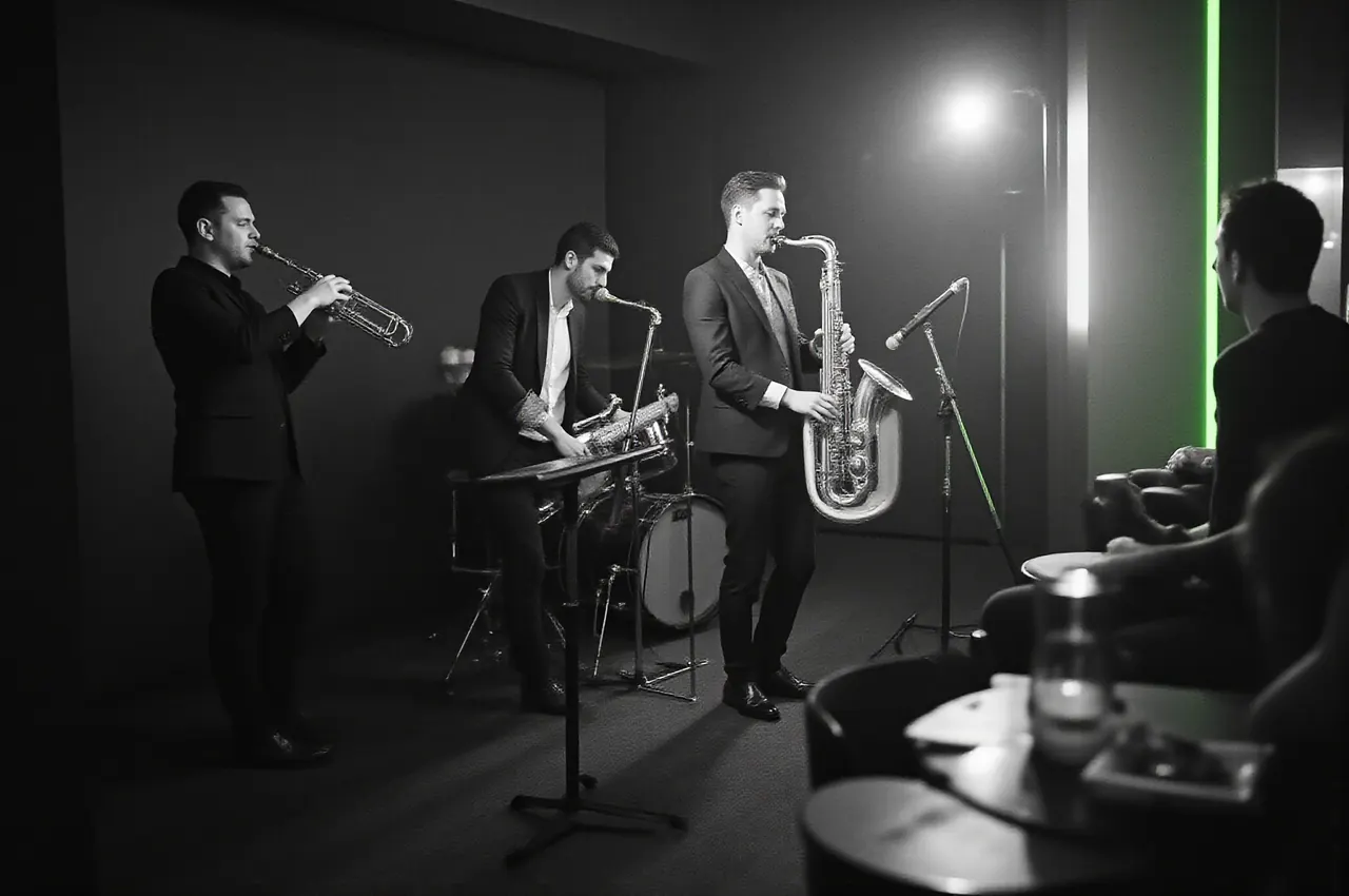 Trio jazzowe grające na małej scenie w lounge, goście słuchają w półmroku